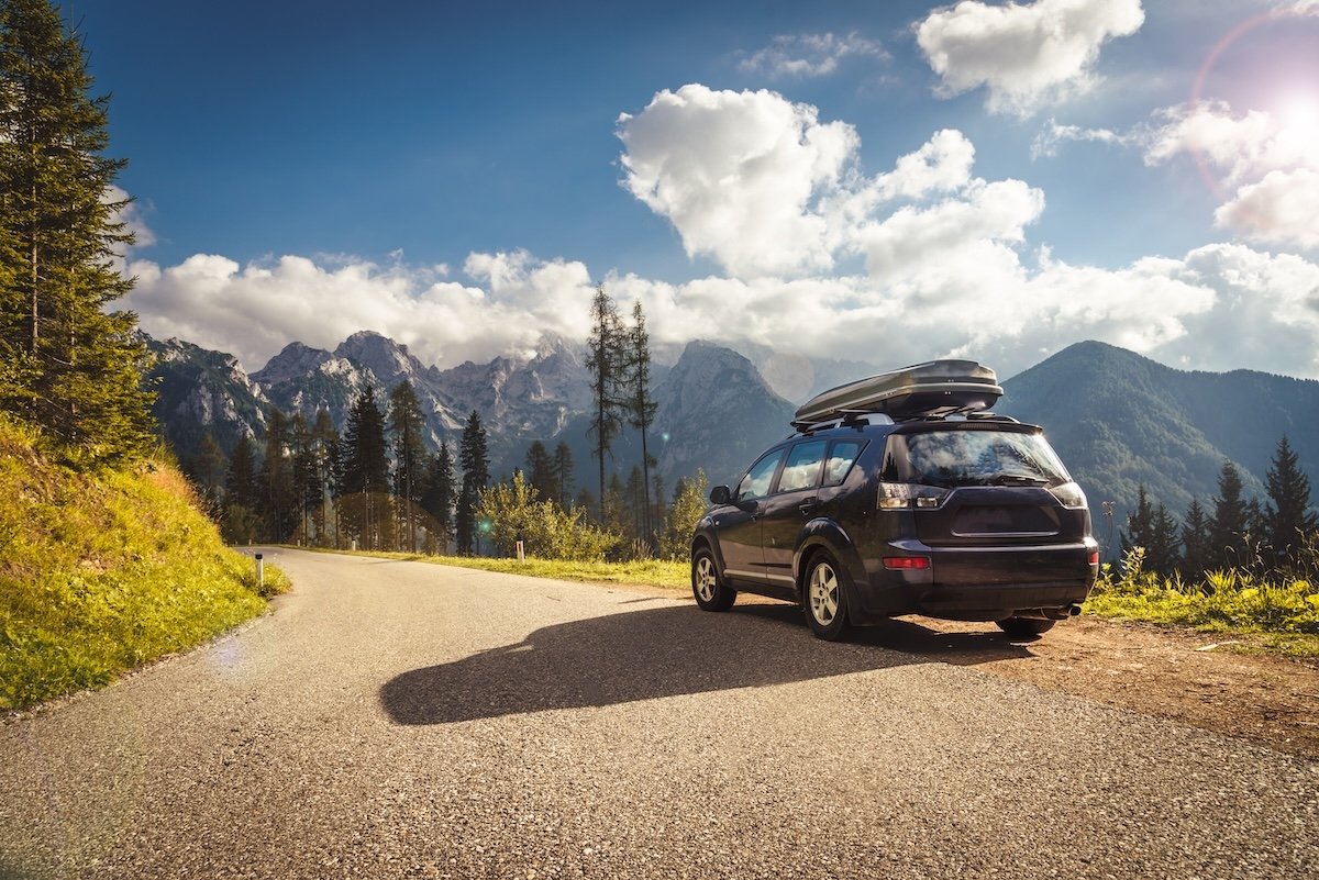 car for traveling with a mountain road. Blue sky