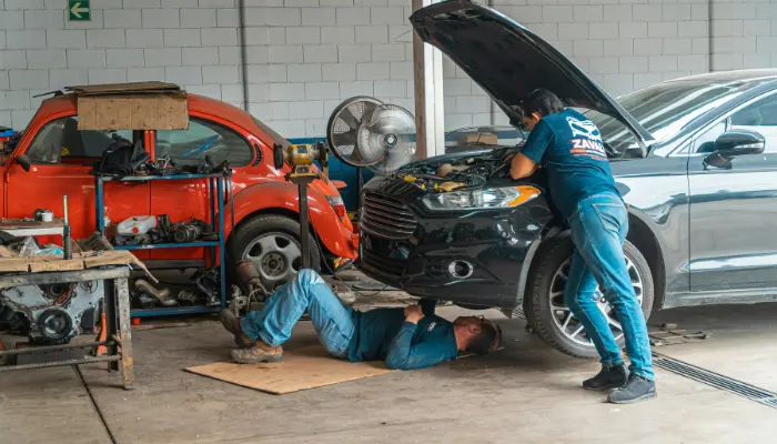 Collision-repair-technician-inspecting-vehicle