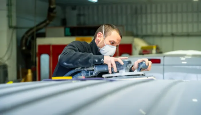 Collision-repair-technician-inspecting-vehicle