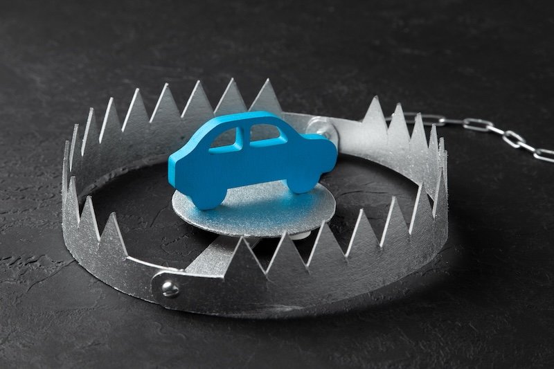 Trap with bait car. The risk of buying bad car. Car insurance. Black background