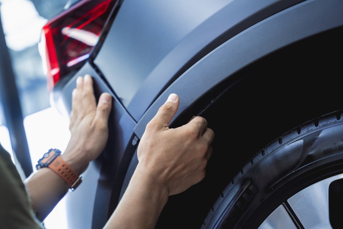 Replacing spare parts on a disassembled car in a car service garage.