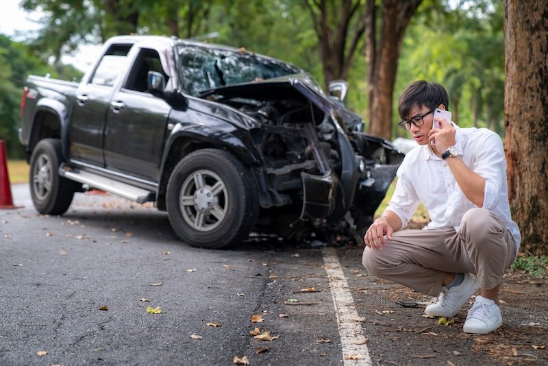 Man calling to insurance call center to help after a car crash accident on the road