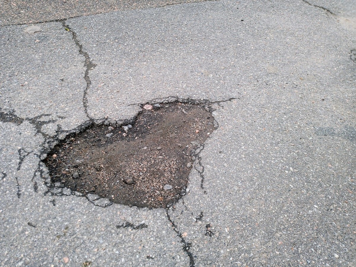 a hole in the asphalt in the shape of a heart. love on the asphalt. a pothole on the asphalt. road repair. a problem with the road surface. close-up. road work. valentine's day.