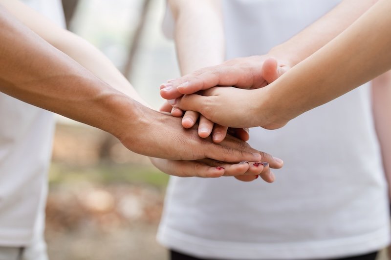 A close-up of hands from volunteers stacking together, symbolizing unity and shared commitment to environmental cleanup efforts. SSUCv3H4sIAAAAAAAACm2NsQrDMAxE/+VmD4FCB/9K6aA4IhWoDsh2oRj/exVn7XSPB3fXsVKRhNgdanplejNibqoBvEk9TEgRlwCSGaLaSjWqcuQpjPPGNvFjt/viNAISVd69zOWanh+PfnpEIKC09YQR/rinv+2c09e7Y4wfPhiA86QAAAA=