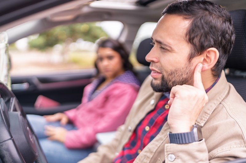 Couple experiencing car problems realizing they have a mechanical failure while traveling by car